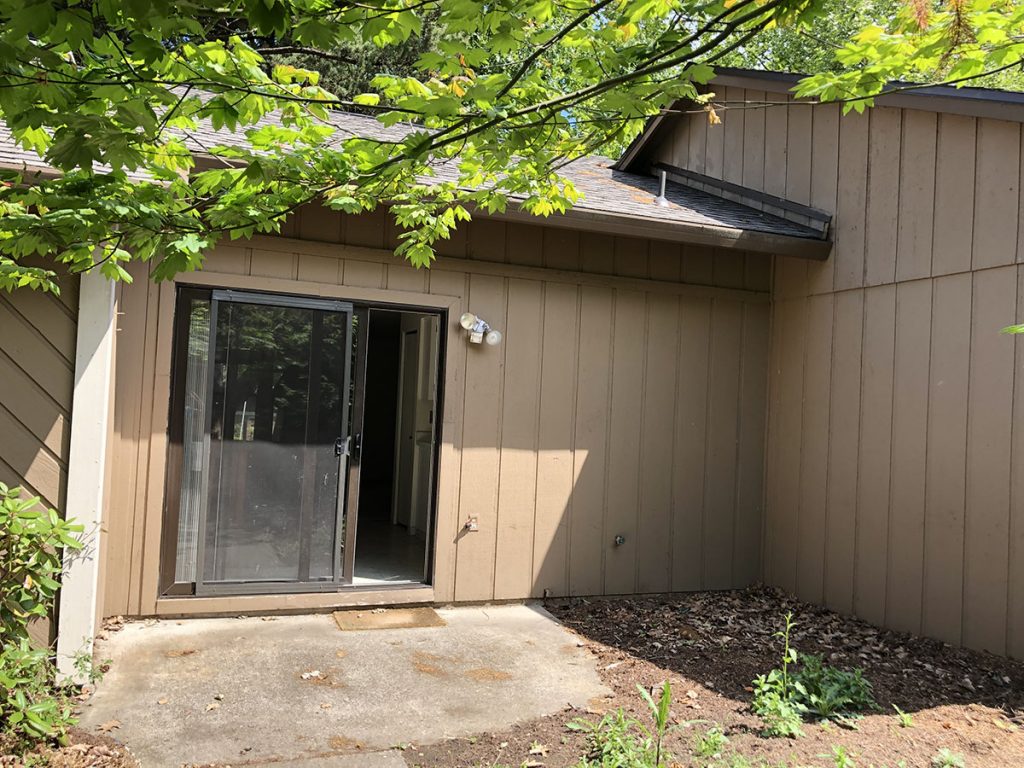 Back entrance before remodel, with sliding door and small concrete porch